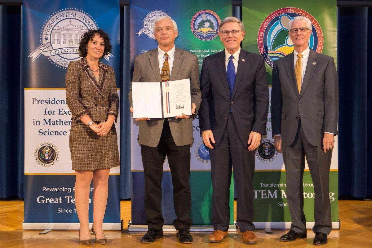 Photo from paemst.org - Mark Howell holding Presidential award with National Science Foundation Directorate for Education and Human Resources Assistant Director, Dr. Karen Marrongelle, White House Office of Science and Technology Policy Director, Dr. Kelvin K. Droegemeier, and National Science Foundation Chief Operating Officer, Dr. F. Fleming Crim