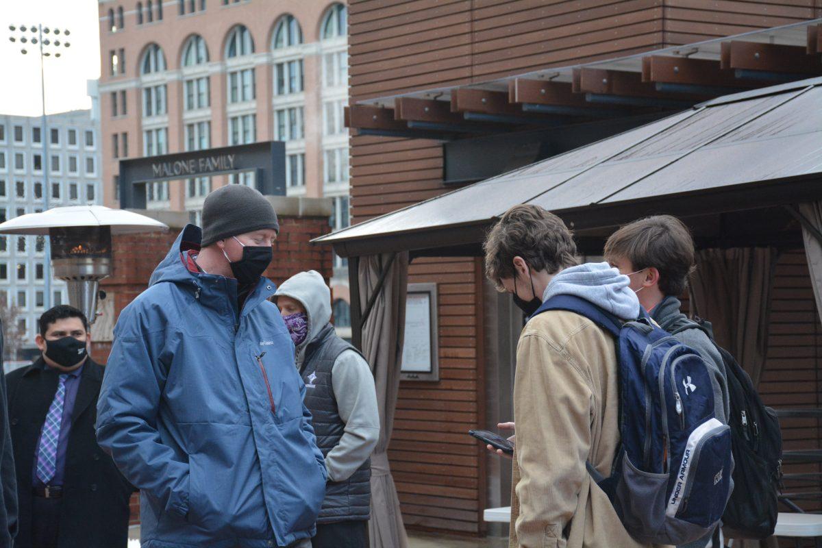 Mr. Jim Kilroy (left) greets and checks students in as they step onto campus each morning. (Photo by Mak Krivka)