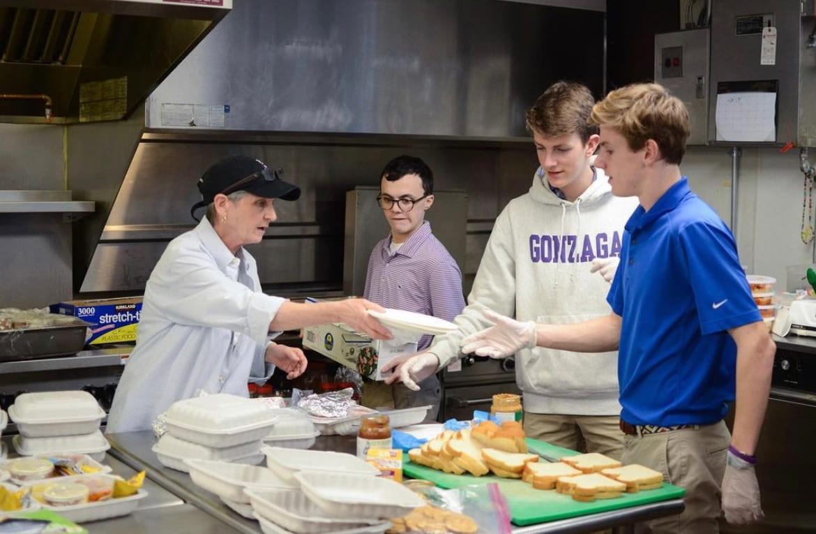 Ms. Patty Tobin and a group of students prepare meals at the McKenna Center. (Gonzagakitchenproject Instagram)