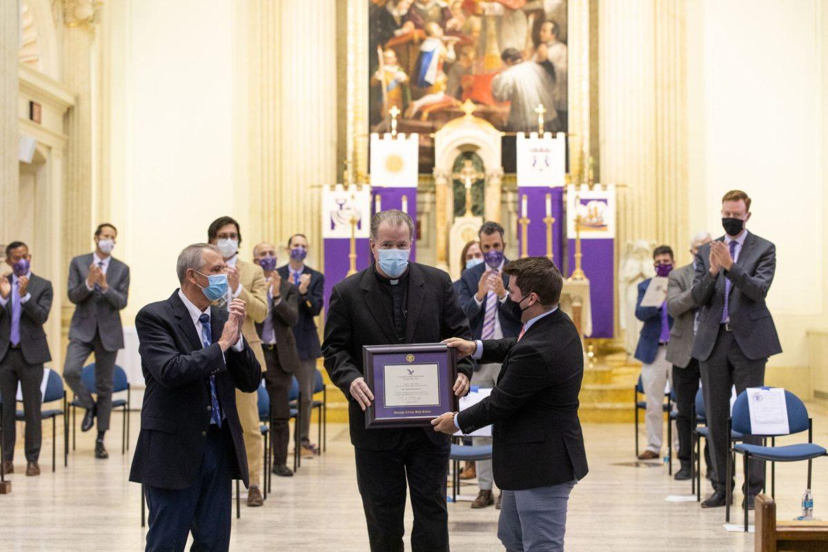 SGA President Mak Krivka presents Fr. Stephen Planning, SJ with an honorary diploma from the Class of 2021 for the work and achievements he has made in his tenure as president. (Photo from Gonzaga Flickr)