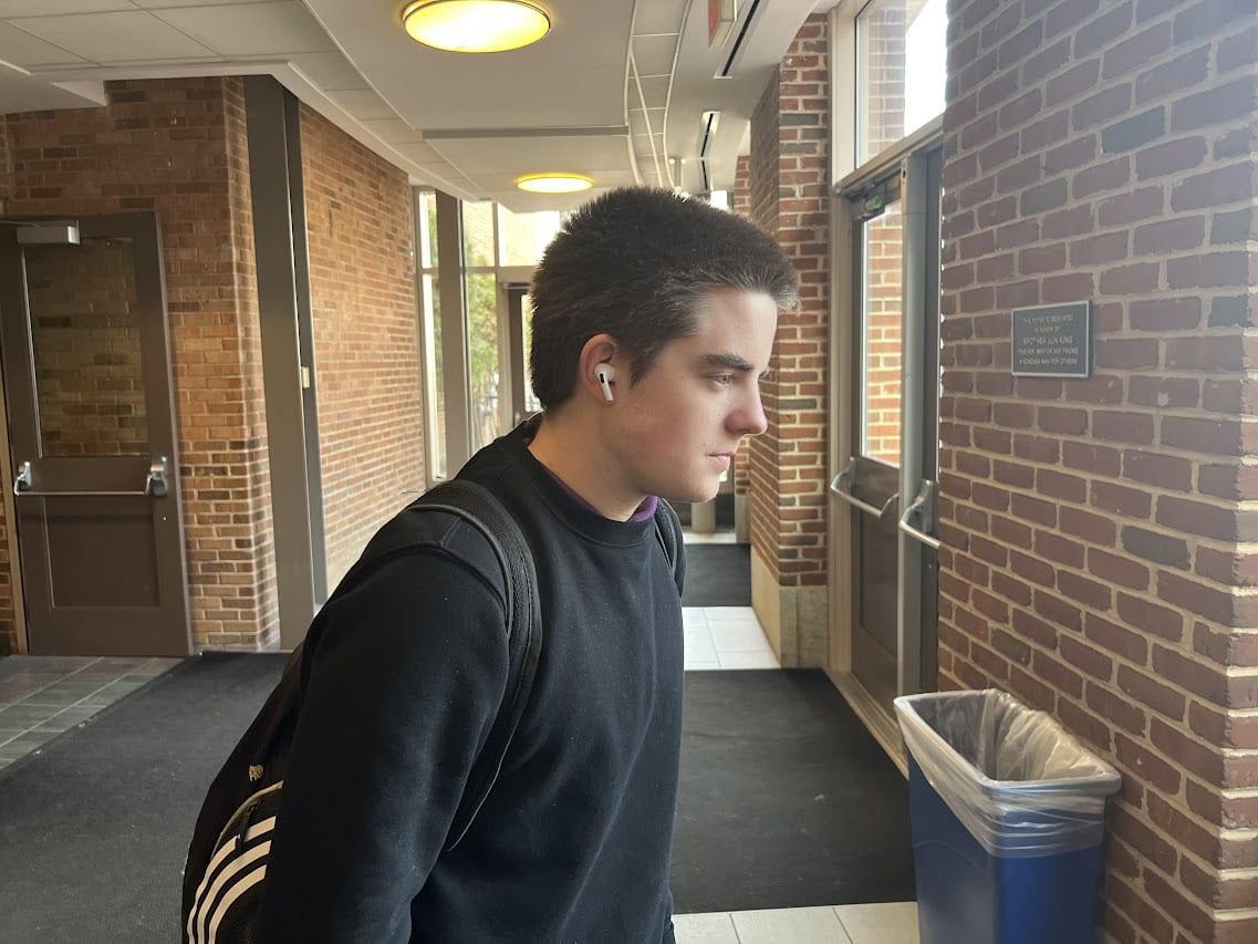 Dalton Enright, senior, wears headphones during a passing period. Photo by Jon Bouker