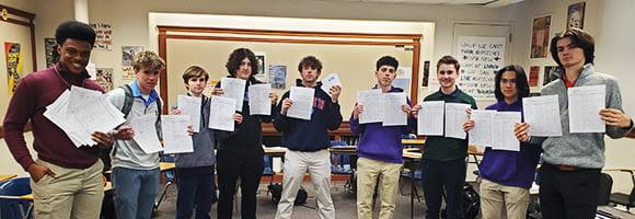 Mrs. Murphy's Social Justice in Action class holds up the over 350 signatures they collected. Photo from Eye Street Headlines.